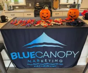 Blue Canopy Marketing and Bayshore Homes table setup for trick-or-treat community event.